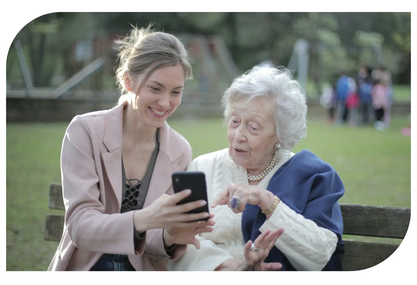 A senior woman and a young family member using the Salyx app together in a park.